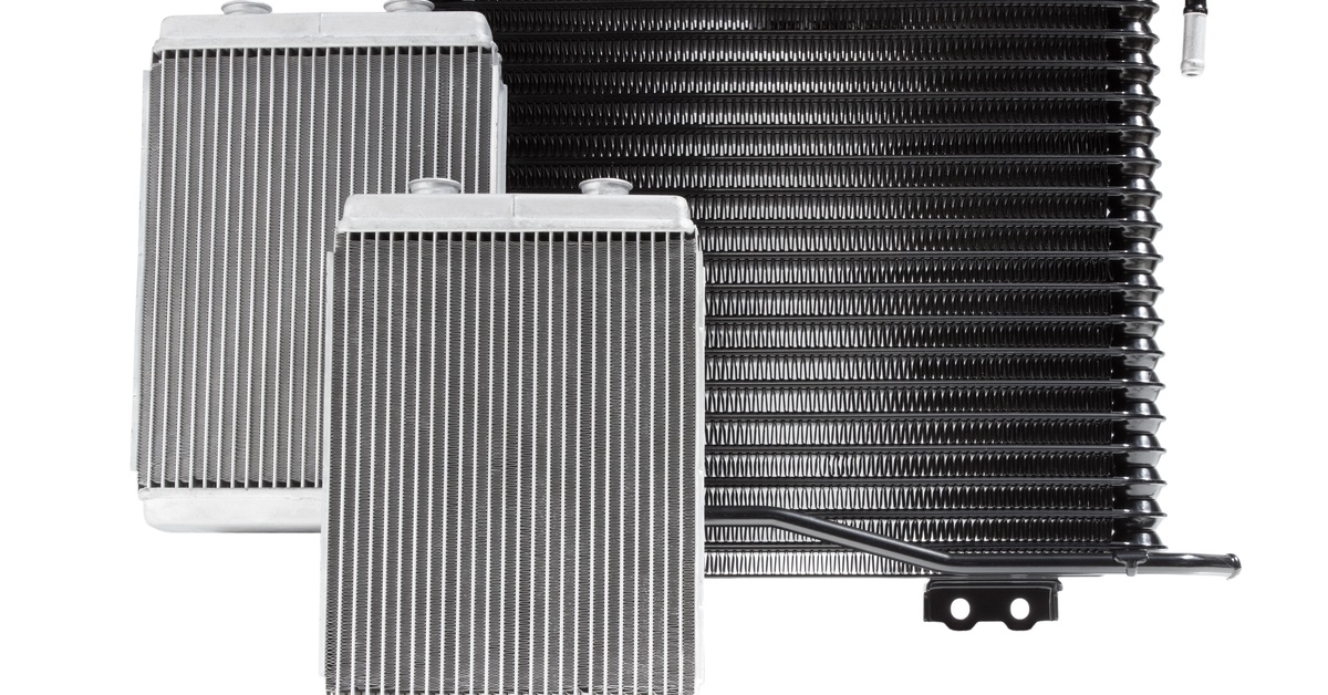 Two car radiators sit next to an external transmission cooler. All three sit against a solid white background.